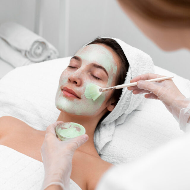 beautician applying face mask female client